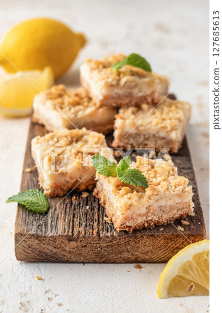 Lemon crumble bars on wooden cutting board, oatmeal lemon bars 127685613
