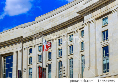 19 April 2025 Washington D.C US Exterior details of Reagan Building in Washington D.C. display American flag against bright blue sky. 19 April 2025 Washington D.C US Exterior details of Reagan Building in Washington D.C. display American flag against bright blue sky. 127685669