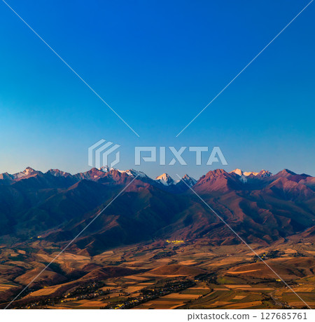 Majestic mountain range with snow-capped peaks at twilight 127685761
