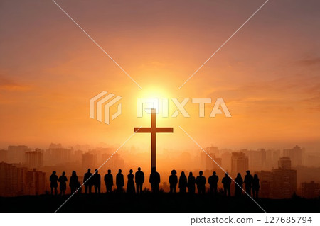 Cross and people at sunset over city. Silhouettes against dramatic urban skyline and glowing sun. 127685794
