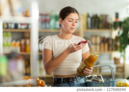 Young woman scanning qr code of peach juice Young woman scanning qr code of peach juice 127686040