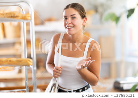 Young woman looking around in bakery Young woman looking around in bakery 127686121