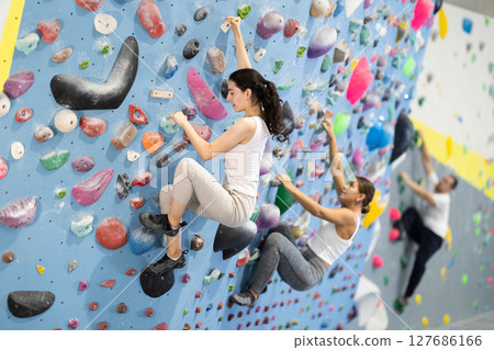 Young woman doing rock climbing on climbing wall Young woman doing rock climbing on climbing wall 127686166