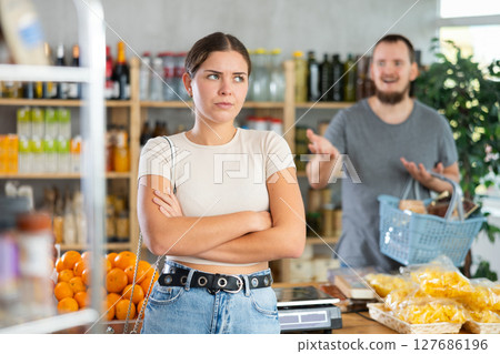 Young man quarrels with woman in grocery store Young man quarrels with woman in grocery store 127686196