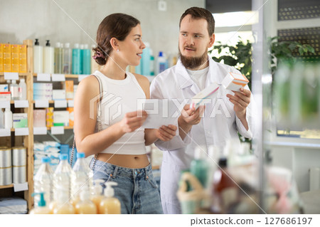 Male pharmacist offers woman prescription pills Male pharmacist offers woman prescription pills 127686197