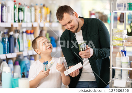 Man and boy choosing toothbrush in store Man and boy choosing toothbrush in store 127686206