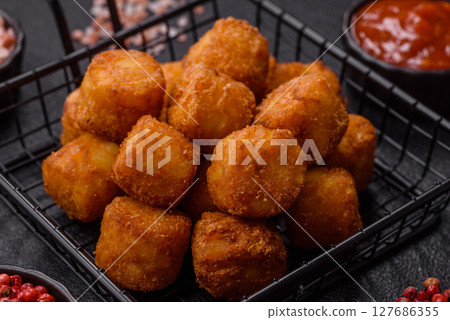 Cheese or potato croquettes, balls fried in breading with salt, spices Cheese or potato croquettes, balls fried in breading with salt, spices 127686355