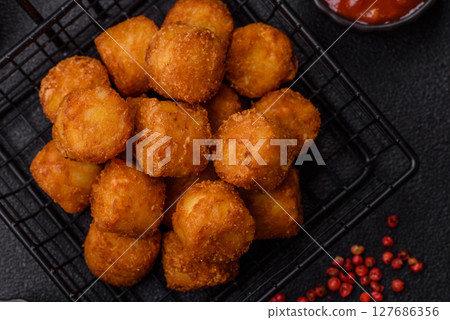 Cheese or potato croquettes, balls fried in breading with salt, spices Cheese or potato croquettes, balls fried in breading with salt, spices 127686356