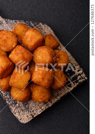 Cheese or potato croquettes, balls fried in breading with salt, spices 127686373