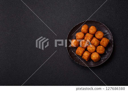 Cheese or potato croquettes, balls fried in breading with salt, spices 127686380