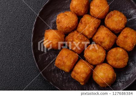 Cheese or potato croquettes, balls fried in breading with salt, spices 127686384