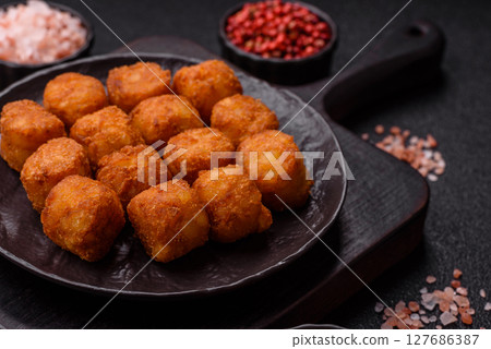 Cheese or potato croquettes, balls fried in breading with salt, spices 127686387