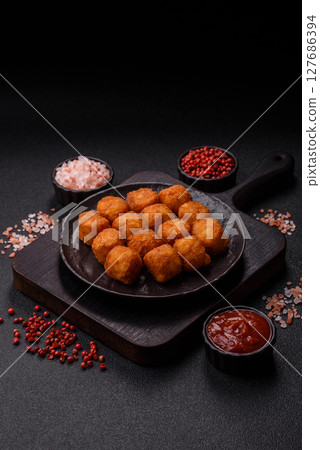 Cheese or potato croquettes, balls fried in breading with salt, spices Cheese or potato croquettes, balls fried in breading with salt, spices 127686394