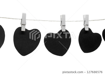 Black paper hearts with copy space hanging on white rope and attached with white laundry pins 127686576