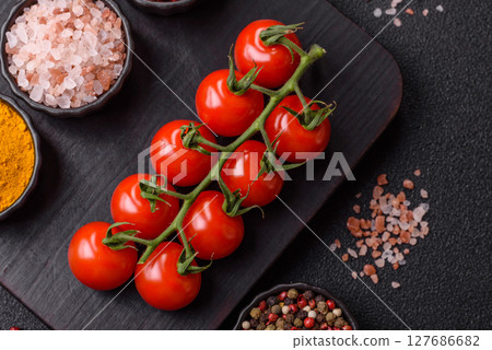 Red cherry tomatoes on a branch, a vegetable as an ingredient for making sauces Red cherry tomatoes on a branch, a vegetable as an ingredient for making sauces 127686682