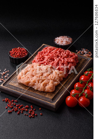 Beef and chicken minced meat, ground of two types fresh raw with salt and spices Beef and chicken minced meat, ground of two types fresh raw with salt and spices 127686834