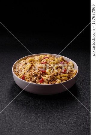 Flakes, chocolate balls and dried fruit for a hearty breakfast 127687069