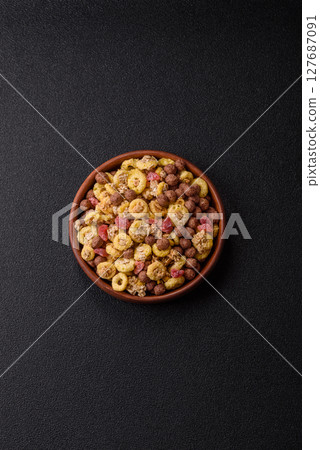 Flakes, chocolate balls and dried fruit for a hearty breakfast Flakes, chocolate balls and dried fruit for a hearty breakfast 127687091