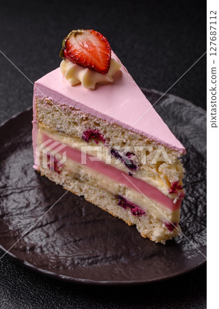 A slice of pink colored puff cake for a birthday celebration A slice of pink colored puff cake for a birthday celebration 127687112