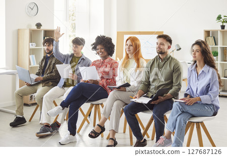 Business Team Asking Questions And Raising Hands During Office Meeting 127687126