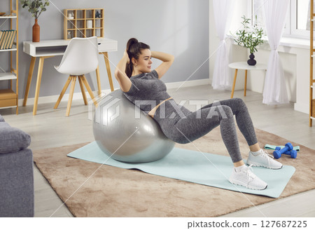 Active Woman Exercising with a Fitball at Home 127687225