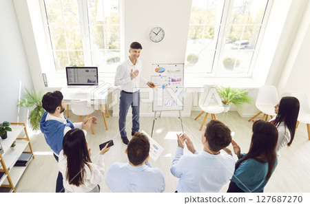 Male manager speaker, businessman gives business presentation to diverse employees group at office Male manager speaker, businessman gives business presentation to diverse employees group at office 127687270