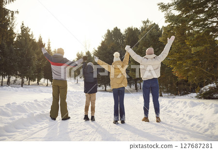 Family enjoys winter fun nature snowy activities hand raising back view. Winter fun laughter joy cherish winter season happiness memories of time together in snowy wonderland winter fun. 127687281