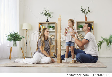 Active Family With Child Building Tower With Wooden Cubes At Home 127687313
