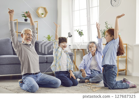 Happy, cheerful grandparents and grandchildren playing games and having fun together 127687325