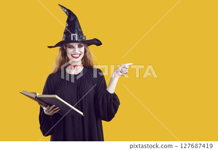 Woman in witch costume pointing finger at copy space, recommending something on Halloween theme. Woman in witch costume pointing finger at copy space, recommending something on Halloween theme. 127687419
