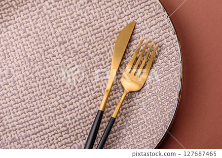 Empty ceramic plate on a monochrome brown background 127687465
