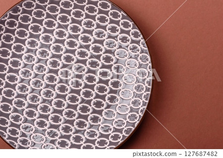 Empty ceramic plate on a monochrome brown background Empty ceramic plate on a monochrome brown background 127687482