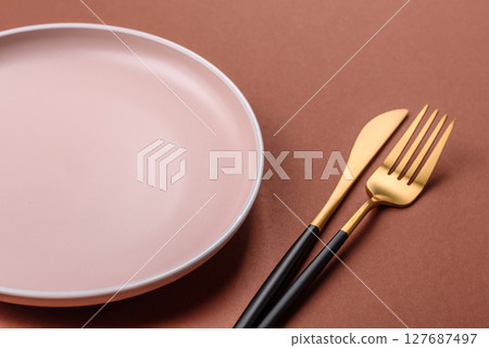 Empty ceramic plate on a monochrome brown background Empty ceramic plate on a monochrome brown background 127687497
