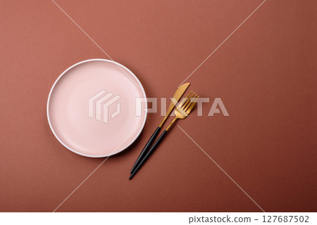 Empty ceramic plate on a monochrome brown background Empty ceramic plate on a monochrome brown background 127687502