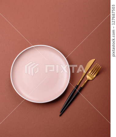 Empty ceramic plate on a monochrome brown background Empty ceramic plate on a monochrome brown background 127687503