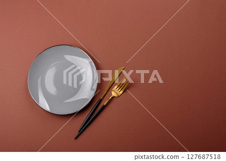 Empty ceramic plate on a monochrome brown background Empty ceramic plate on a monochrome brown background 127687518