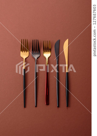 Knife and fork, cutlery on a brown dining table 127687603