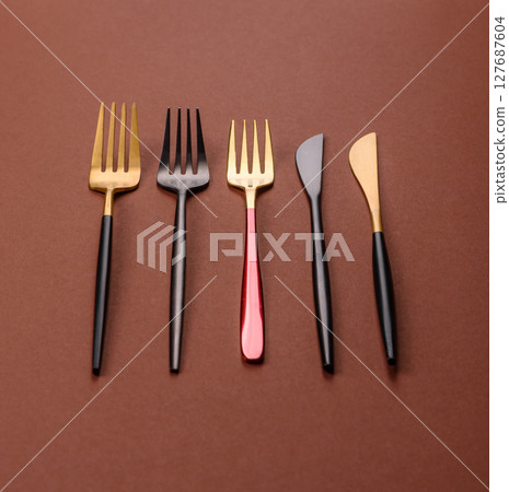 Knife and fork, cutlery on a brown dining table 127687604