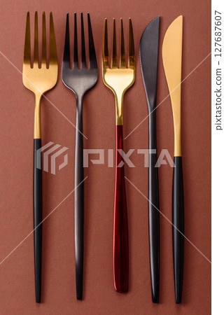 Knife and fork, cutlery on a brown dining table 127687607
