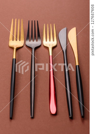 Knife and fork, cutlery on a brown dining table 127687608