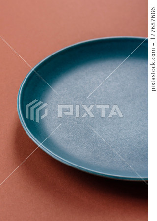 Empty ceramic plate on a monochrome brown background Empty ceramic plate on a monochrome brown background 127687686