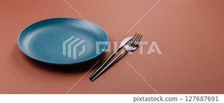 Empty ceramic plate on a monochrome brown background Empty ceramic plate on a monochrome brown background 127687691