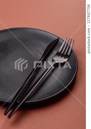 Empty ceramic plate on a monochrome brown background 127687706