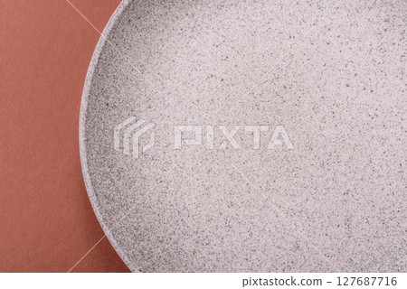 Empty ceramic plate on a monochrome brown background Empty ceramic plate on a monochrome brown background 127687716