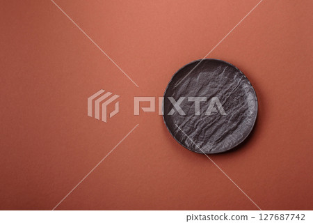 Empty ceramic plate on a monochrome brown background Empty ceramic plate on a monochrome brown background 127687742