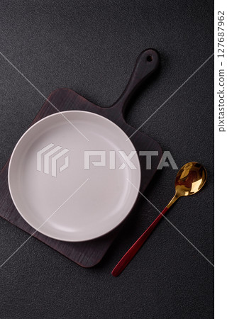 Empty plate with spoon, cutlery for dinner table Empty plate with spoon, cutlery for dinner table 127687962