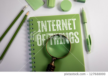 Internet of Things Text on Green Notebook with Magnifying Glass and Stationery on White Background 127688000