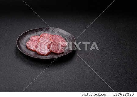 Sliced salami sausage, smoked meat, delicious deli snacks 127688880