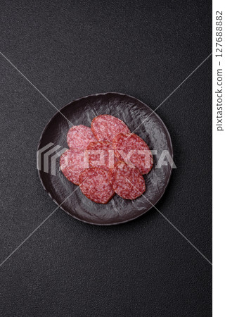 Sliced salami sausage, smoked meat, delicious deli snacks Sliced salami sausage, smoked meat, delicious deli snacks 127688882