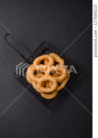 Onion rings or squid rings fries crispy, savory with sauce 127689215